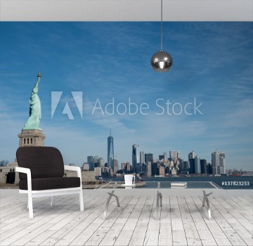 Picture of Statue of Liberty in Profile with Manhattan skyline in background Bright sunny day Wall Street and Financial District of lower Manhattan in the background View from ferry across the harbor